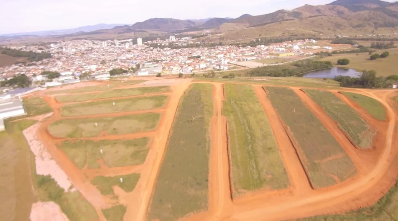 Vista aérea do loteamento em terraplanagem com a cidade ao fundo