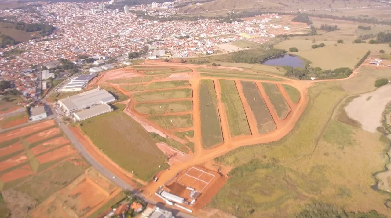 Vista aérea do loteamento em terraplanagem com a cidade ao fundo