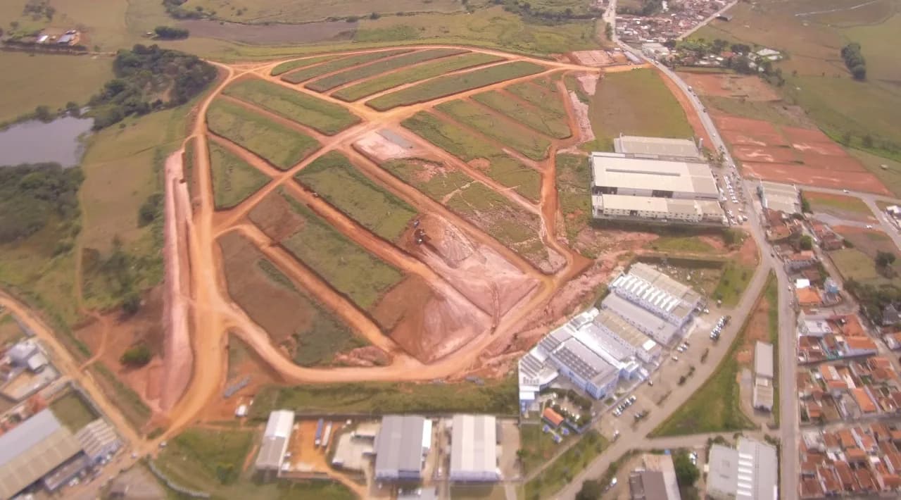 Vista aérea do loteamento em terraplanagem com a cidade ao fundo