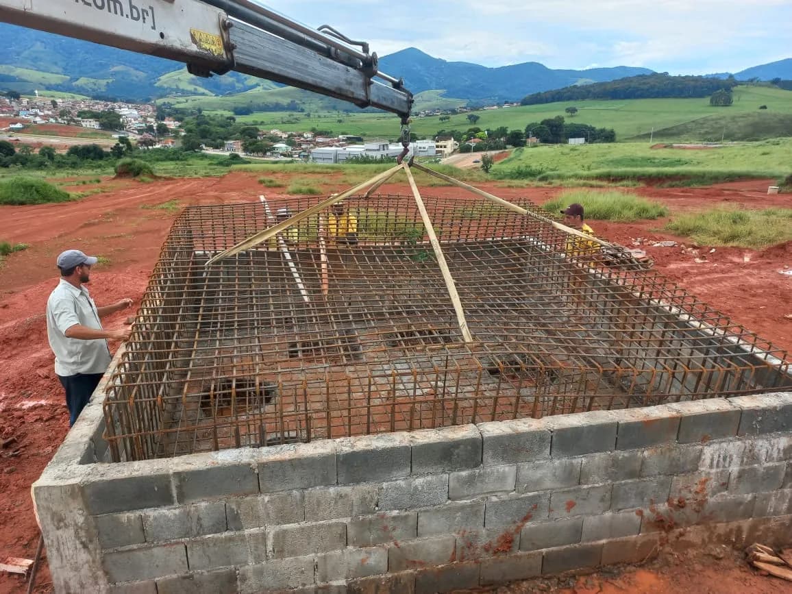 Equipe montando armadura sobre a base do reservatório