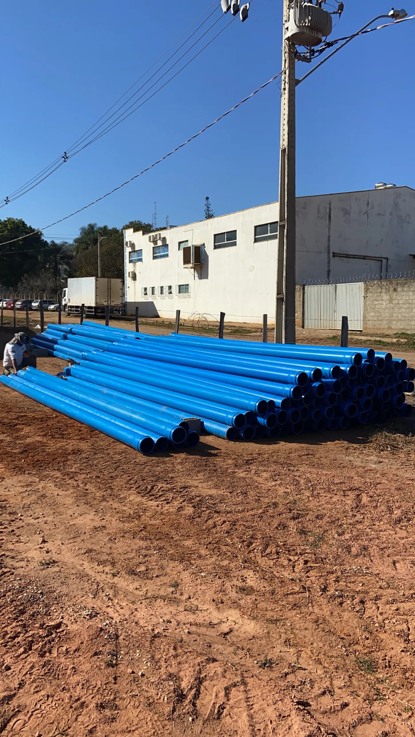 Tubos azuis de PVC estocados no canteiro de obras