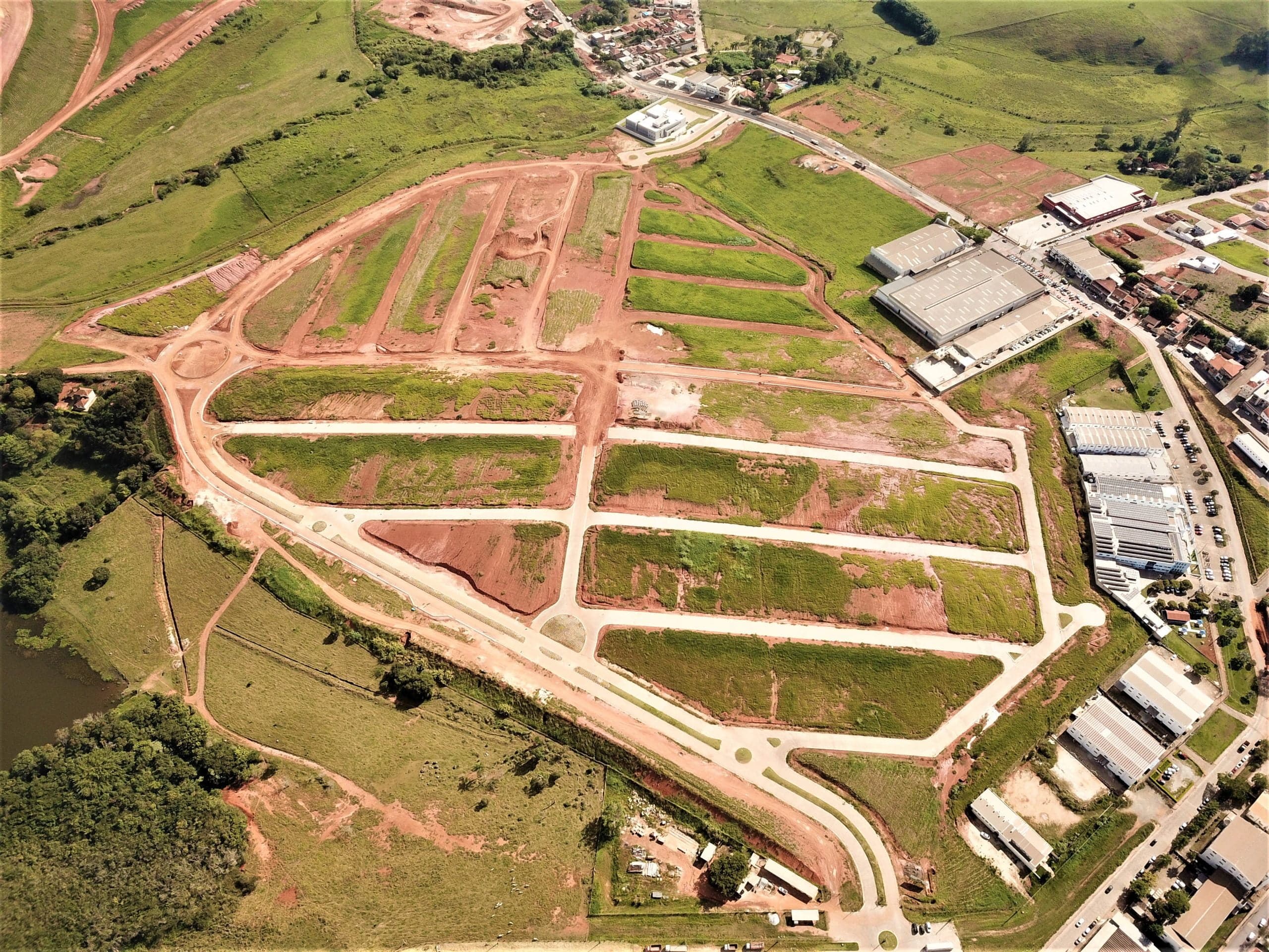 Vista aérea do Loteamento Colina das Palmeiras, mostrando ruas e lotes entre montanhas